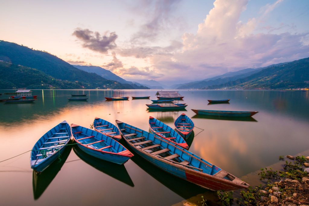 travelpons asian location lake in valley multiple wooden boats on lace