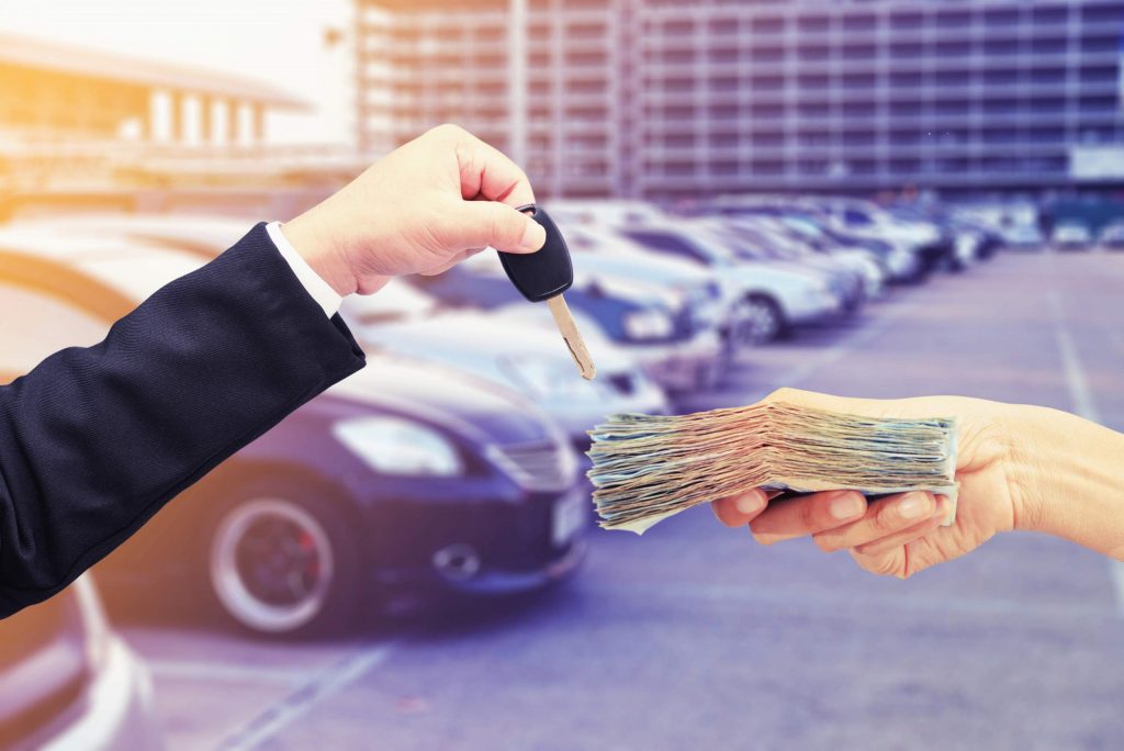 selling car handing keys receiving cash car in background